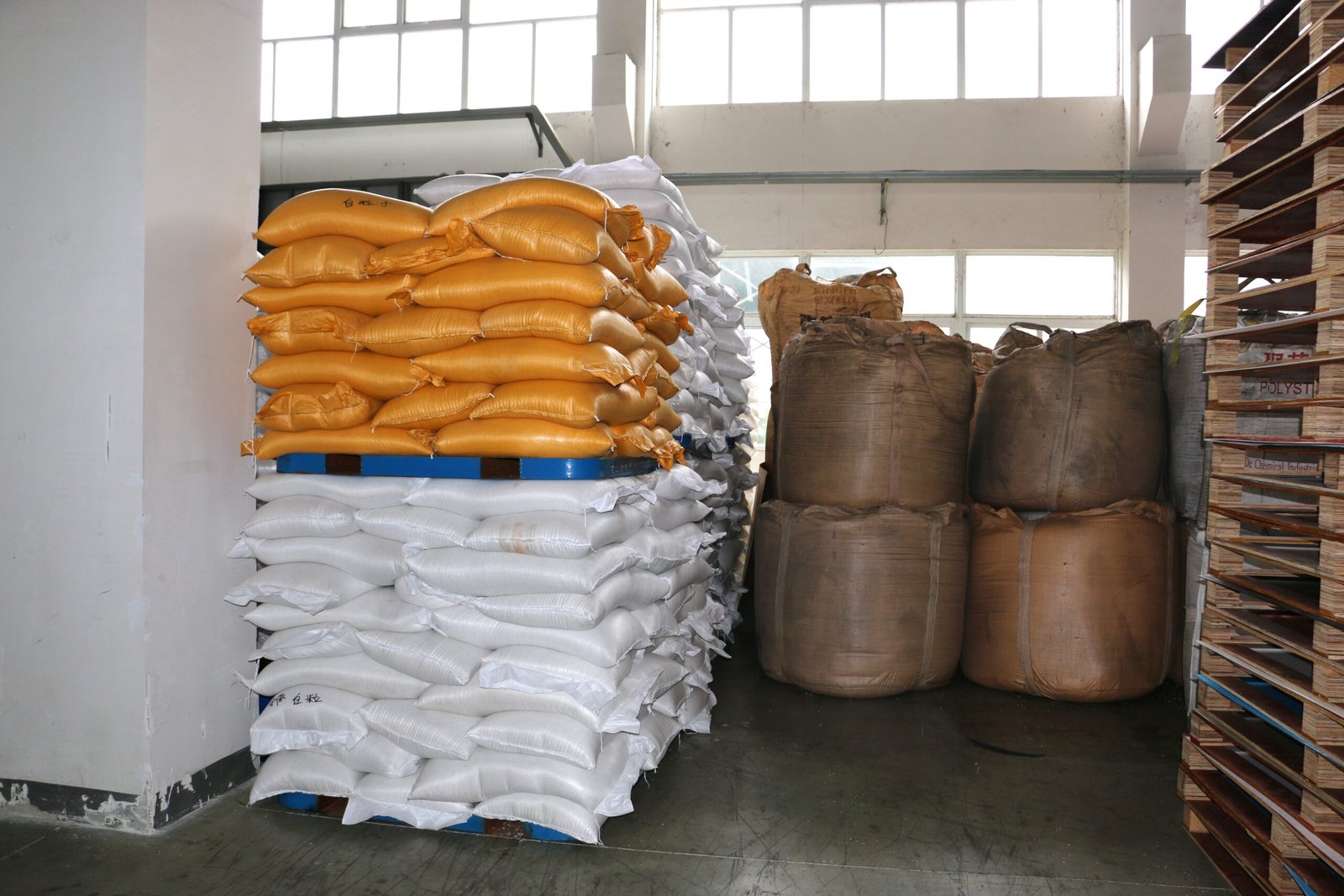 Stacked PP hollow sheet raw materials stored in warehouse for cutting, creasing, and folding into corrugated plastic boxes