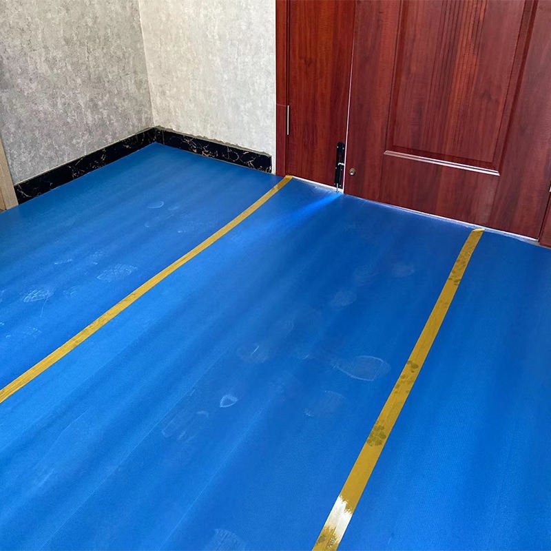 PP floor protection sheet covering wooden floor to prevent scratches and damage during construction